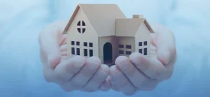 A property manager is holding dummy home in Chicago in her hands